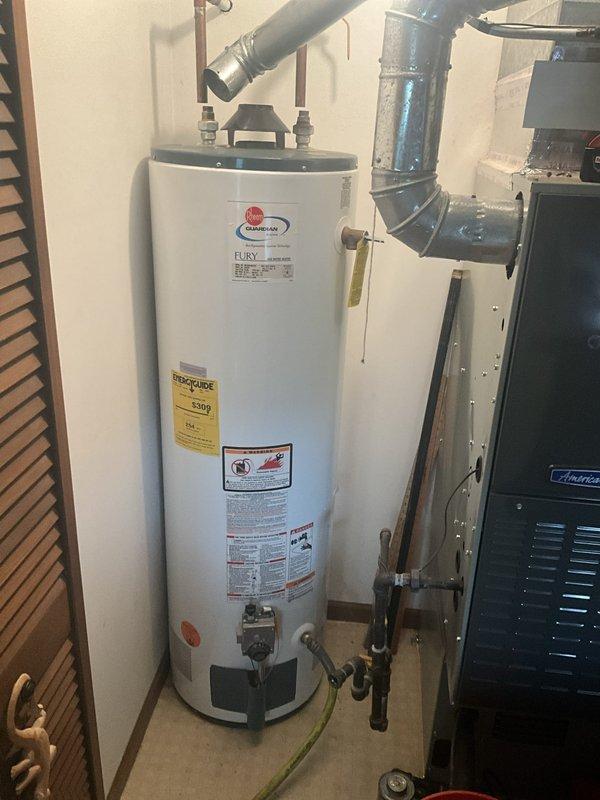 Completed installation of a 40-gallon residential tanked water heater as a first-time service call. Installed new unit with proper plumbing connections including copper supply lines, galvanized piping, gas line hookup with flexible yellow connector, and appropriate venting configuration. All connections secured with brass fittings and valves, drain valve installed, and unit positioned in utility room alongside existing HVAC equipment with adequate clearance for maintenance and code compliance.