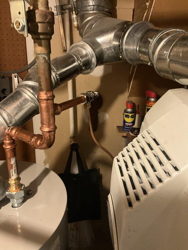Responded to service call for Bradford White tanked water heater experiencing water accumulation in drain pan and blinking diagnostic lights. Performed visual inspection of unit and surrounding plumbing connections, documented existing conditions with photographs showing copper supply lines, ventilation system, and water heater installation in utility area. Assessed status indicator lights on unit to determine fault code and identified potential leak source requiring attention.