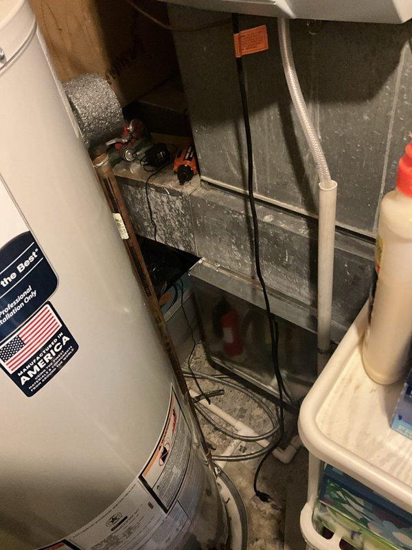 Responded to service call for Bradford White tanked water heater experiencing water accumulation in drain pan and blinking diagnostic lights. Performed visual inspection of unit and surrounding plumbing connections, documented existing conditions with photographs showing copper supply lines, ventilation system, and water heater installation in utility area. Assessed status indicator lights on unit to determine fault code and identified potential leak source requiring attention.