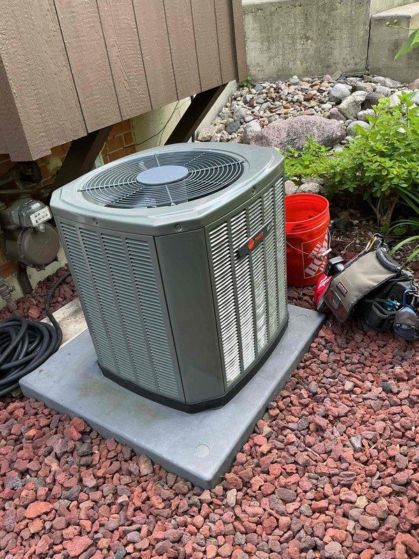 Completed comprehensive air conditioning tune-up on a 6-year-old outdoor condensing unit. Removed top panel to access condenser coil, which exhibited significant accumulation of dirt, dust, debris, and organic growth with yellowish-green discoloration throughout the fin surfaces. Thoroughly cleaned condenser coil to remove buildup and restore proper airflow and heat transfer efficiency. Performed standard maintenance inspection of all accessible components, reassembled unit, and verified proper operation upon completion.