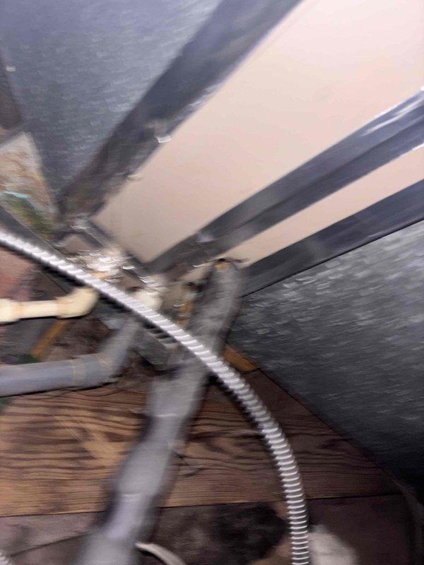 Responded to service call for air conditioning system blowing warm air in older home with unit components located in attic crawl space. Accessed confined attic area to inspect HVAC equipment, ductwork, and associated refrigerant lines. Evaluated system components including condensate drainage, electrical conduits, and mechanical connections at junction points where multiple utility lines intersect with structural framing. Documented existing conditions of aged equipment and infrastructure routing through unconditioned space for service records.