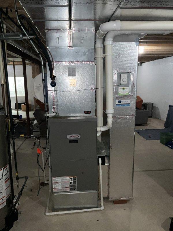 Completed full system HVAC estimate for residential property with existing Lennox equipment. Assessed basement-mounted vertical Lennox furnace with air handler/evaporator coil unit and outdoor Lennox condenser unit installed on exterior concrete pad against house foundation. Evaluated complete system including ductwork configuration with flexible ducting, PVC condensate drainage piping, refrigerant line sets running from outdoor unit to indoor components, and electrical connections. Documented current equipment specifications, installation configuration in mechanical room with concrete flooring and unfinished ceiling joists, and outdoor unit placement relative to building structure and landscaping. Provided comprehensive replacement options and upgrade recommendations based on home comfort requirements and existing system layout.