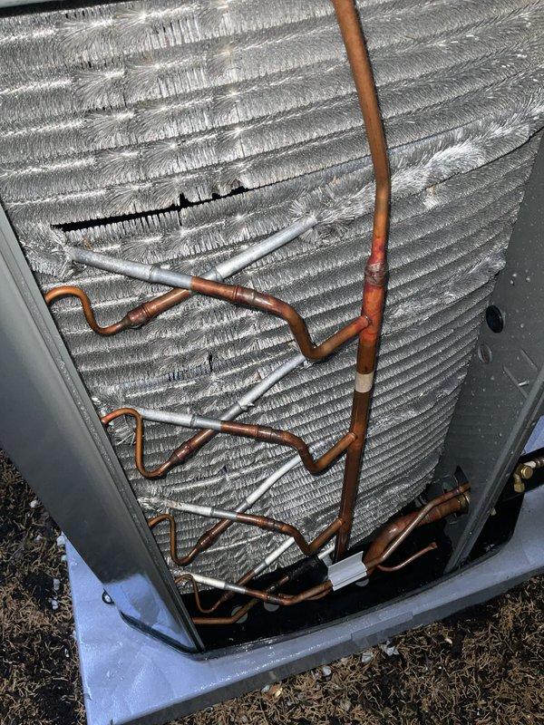 Completed comprehensive BFMA tune-up on residential central air conditioning system located in side yard between brick wall and wooden fence. Performed standard maintenance protocol including inspection of outdoor condensing unit with louvered metal grille, verification of proper installation on concrete pad, examination of refrigerant lines with white insulation running to indoor components, and detailed assessment of evaporator coil assembly with horizontal aluminum fins and copper refrigeration circuit. System evaluated for proper operation with all components found in functional condition following tune-up procedures.