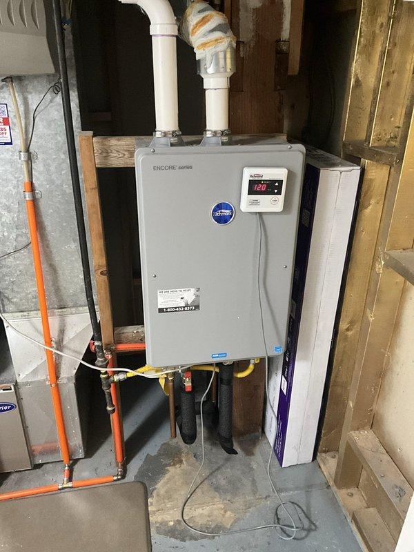 Completed comprehensive tune-up and maintenance on Encore series tankless water heater system addressing reported low water pressure concerns. Performed standard BFPMA protocol including system inspection, flushing procedures, filter cleaning, and verification of all inlet/outlet connections and PVC venting components. Confirmed unit operating at proper temperature setpoint of 120°F with digital display functioning correctly, all piping connections secure, and water flow restored to normal pressure levels.