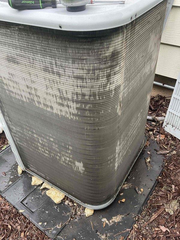 Completed comprehensive BFMA tune-up on 11-year-old residential air conditioning system. Inspected and documented return air filter showing moderate dust accumulation on pleated media within decorative frame housing. Performed exterior unit maintenance including coil cleaning to address significant dark staining and debris buildup on condenser fins, applied appropriate cleaning solution, and cleared surrounding area of mulch and leaf debris to ensure proper airflow and system efficiency.