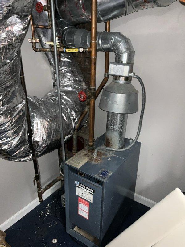 Completed comprehensive assessment of existing boiler system and provided detailed estimate for full boiler replacement and humidifier installation. Evaluated current equipment configuration including water heater/boiler unit, associated copper piping with shutoff valves, flexible ductwork, and ventilation components. Documented existing system layout with photographs showing current boiler placement, piping network, and ductwork connections to support accurate replacement specifications. Reviewed installation requirements and discussed project scope with homeowner, confirming afternoon availability for future installation work.