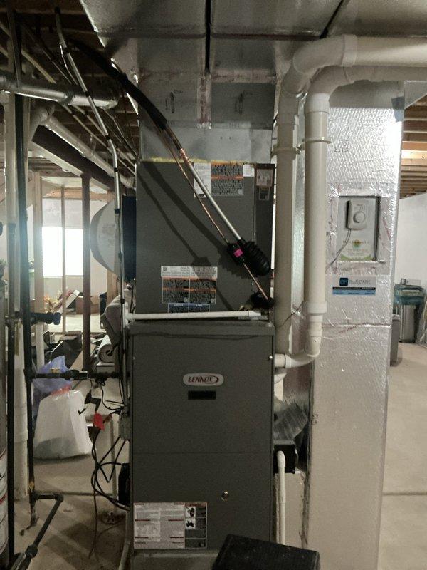 Completed installation of Lennox ML13KC1 1-ton air conditioning system with P200 cased evaporator coil and Lennox control module. The outdoor condensing unit was positioned on a ground-level pad adjacent to the electrical meter on the side of the residence, with the indoor cased coil integrated above the existing Lennox furnace in the basement mechanical room. All refrigerant lines, electrical connections, and condensate drainage were properly installed and tested to ensure system functionality and compliance with manufacturer specifications.