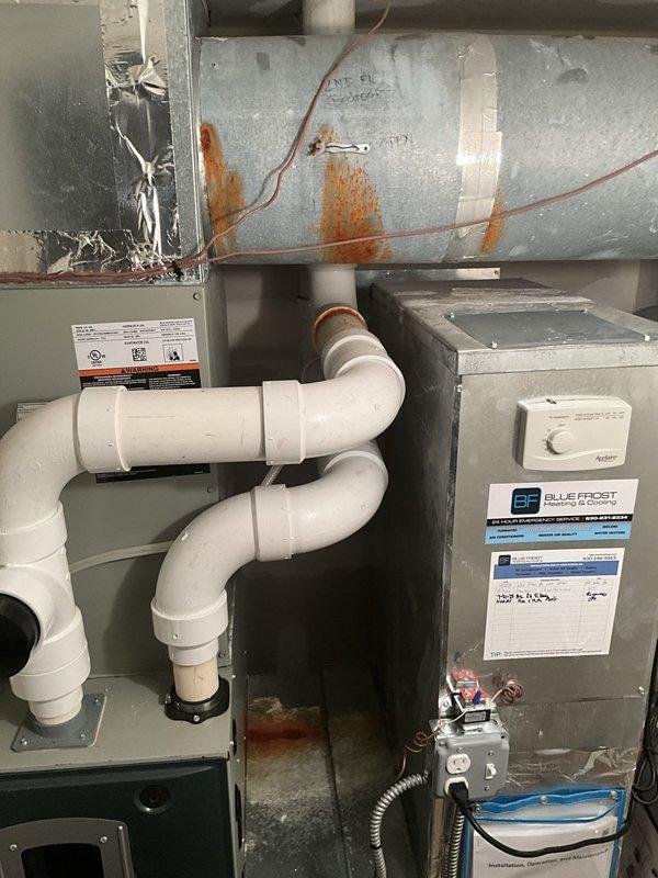 Responded to no cooling complaint for upstairs unit located in attic/crawlspace. Upon arrival, performed diagnostic inspection of HVAC system including condensate drain assembly, ductwork, and air handler components. Inspected Aprilaire equipment, verified electrical connections, and examined flexible ductwork for proper airflow. System components photographed for documentation purposes, showing condensate piping configuration, air handler installation, and associated mechanical equipment in operational condition.