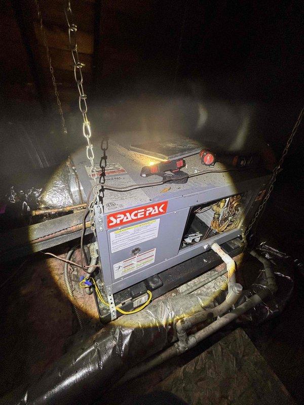 Responded to no cooling complaint where air handler was circulating but not producing cold air. Upon inspection, found Space Pak HVAC system in attic with excessive condensation and moisture accumulation around the unit, indicating potential evaporator coil freezing or drainage issues. Documented equipment condition including control panel status and ductwork configuration. Instructed customer to keep system off to prevent further complications pending diagnostic completion and necessary repairs.