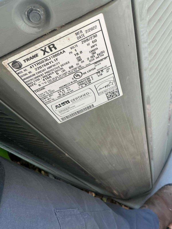 Performed diagnostic evaluation on Trane XR 4TTX003G100RAAAA air conditioning system manufactured in February 2022. Assessed unit for soft start capacitor installation feasibility and evaluated condenser coil condition to determine cleaning requirements. Documented equipment specifications and current operational status with detailed photography of unit nameplate and condenser coil assembly.