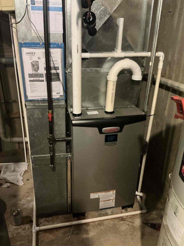 Completed standard furnace installation of Lennox EL297UH unit in basement mechanical room. Installation included proper configuration of condensate drainage system with PVC trap and piping, reinstallation of existing thermostat, filter, and return drop ductwork. All components installed per manufacturer specifications with appropriate venting and drainage systems verified operational.