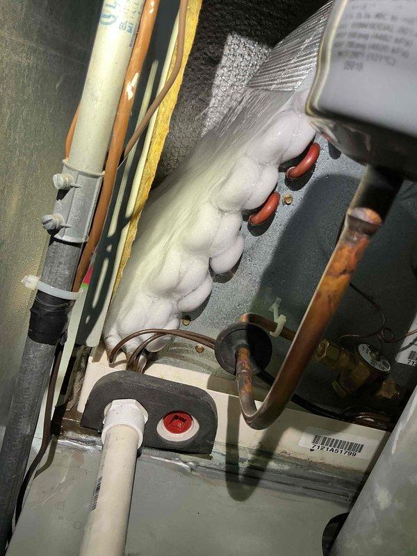 Responded to service call for bubbling water coming from drain pipe. Upon arrival, performed diagnostic evaluation of air conditioning system. Connected manifold gauges to measure system pressures and temperatures. Discovered evaporator coil heavily frosted over, indicating restricted airflow or low refrigerant charge causing excessive condensation and drainage issues. Tested system operation and documented conditions with photos showing frost accumulation on copper refrigerant lines and operating pressures. Identified cause of water drainage problem as direct result of frozen evaporator coil condition requiring further service to address underlying airflow restriction or refrigerant charge issue.