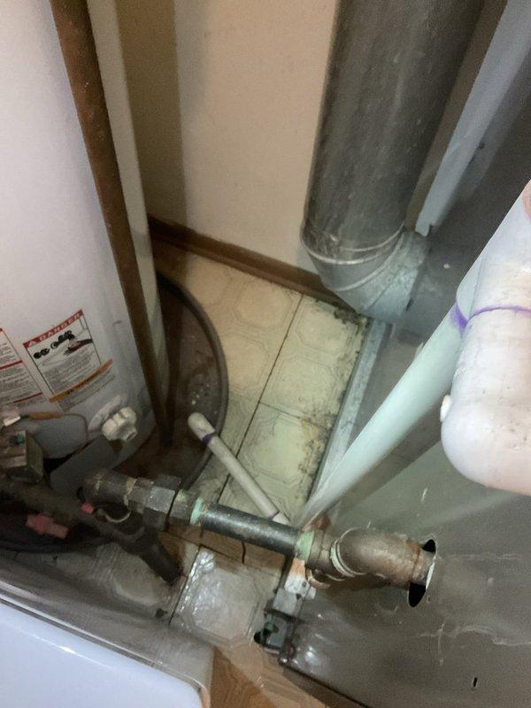Responded to after hours call for water leaking from 5-year-old air conditioning system. Upon inspection, found standing water with visible discoloration and debris accumulation in condensate drip pan beneath air handler unit. Identified clogged condensate drain line as source of leak, preventing proper drainage from evaporator coil during cooling operation.