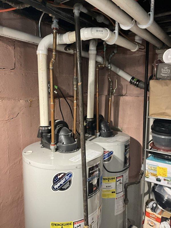 Responded to emergency call for flooded basement with 3-4 inches of standing water. Diagnosed dual water heater system where one unit displayed 7-flash error code indicating failure. Inspected both tanked water heaters, evaluated piping connections, drainage systems, and electrical components. Documented equipment condition including water damage to concrete floor and identified malfunctioning unit requiring repair or replacement to restore hot water service to the residence.