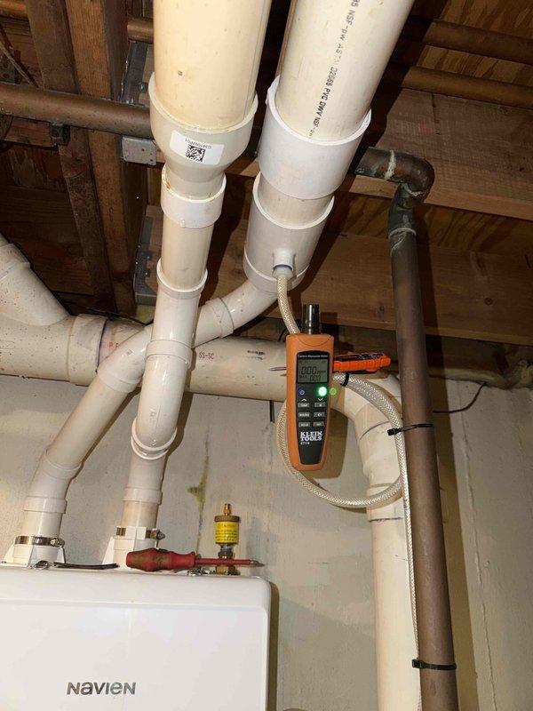 Responded to customer report of carbon monoxide detection from Navien boiler system. Upon arrival, performed comprehensive carbon monoxide testing throughout the mechanical space and at the boiler unit using calibrated Klein Tools CO meter. Testing confirmed zero parts per million (0 ppm) carbon monoxide present in the area and at all exhaust points. Inspected PVC venting system, flue connections, and combustion air supply for proper installation and clearances. All components found to be functioning within normal parameters with no evidence of CO production or venting issues.