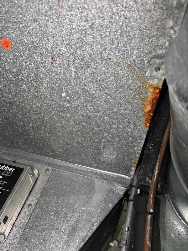 # No Cool Service Call

Responded to no cooling complaint affecting entire home. Upon inspection, discovered significant ice buildup on supply ductwork and evaporator coil section, indicating restricted airflow or low refrigerant charge. Observed rust and corrosion on interior components near condensate area, suggesting possible moisture intrusion or drainage issues. 

Documented frozen ductwork with heavy frost accumulation on metal surfaces and elbow joints. System shutdown required to allow ice to thaw before further diagnostics could be performed. Recommended follow-up inspection after thaw cycle to check refrigerant levels, airflow restrictions, filter condition, and blower motor operation to determine root cause of freezing condition.