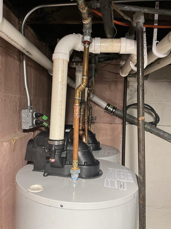 Removed and disposed of two existing water heaters after isolating and draining both units. Installed one new 50-gallon power vent Bradford White water heater and one new 40-gallon power vent Bradford White water heater in basement. Elevated both units approximately 8 inches on concrete block platforms for proper clearance and drainage. Modified and reconnected all gas supply lines, cold water inlet and hot water outlet piping using copper connections, and reconfigured PVC power vent flue systems to accommodate new equipment placement. Verified all connections for proper operation, tested gas pressure and combustion, confirmed adequate venting, and ensured no leaks in water or gas lines. Units covered under 6-year tank warranty and 1-year parts and labor warranty.