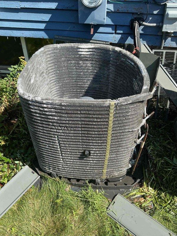 Completed comprehensive BFMA preventative maintenance tune-up on residential air conditioning system with cylindrical condenser coil configuration. Inspected outdoor condenser unit, noting moderate accumulation of dirt and debris on aluminum fins and coil surfaces consistent with normal outdoor operation. Performed standard maintenance procedures including system performance evaluation, component inspection, and documentation of unit condition showing typical weathering for equipment age range of 2-5+ years.