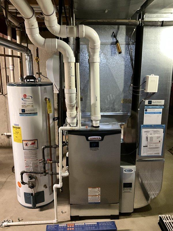 Completed comprehensive BFMA tune-up service on 14+ year old Lennox furnace and air conditioning system during morning appointment window. Performed full AC tune-up including system inspection, verified thermostat operation (Honeywell programmable unit displaying proper temperature readings and functionality), inspected all mechanical components in basement installation, checked air filter access, and evaluated ductwork and PVC condensate drainage system. All equipment found in clean operational condition with proper manufacturer labeling and safety information intact.
