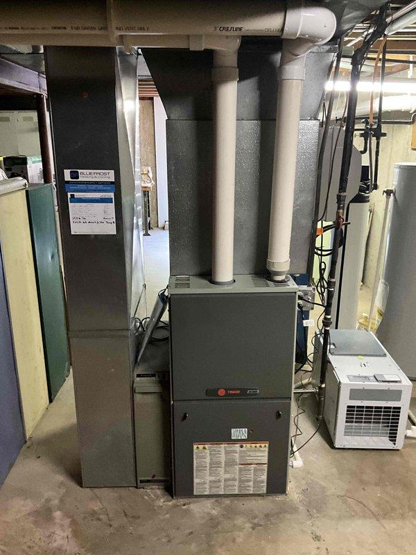 Completed installation of Trane air conditioning system including 5TTR5042A1000 condensing unit and 5PXCC005AS3HA evaporator coil. Integrated new equipment with existing furnace infrastructure, established refrigerant lines and drainage connections, and reinstalled thermostat to ensure proper system communication and climate control functionality.