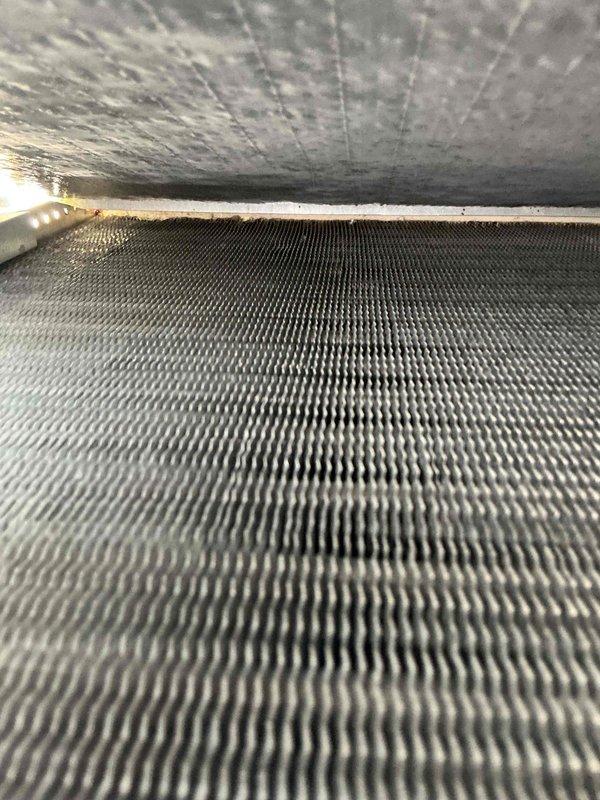 Performed comprehensive air conditioning tune-up on residential HVAC system over two years old. Accessed and inspected return air filter, which showed moderate dust accumulation and discoloration indicating normal use since last replacement. Examined evaporator coil assembly, noting dust and debris buildup on aluminum fins with some heavier accumulation in certain areas. Completed standard maintenance protocol including system inspection, filter evaluation, and coil assessment to ensure optimal cooling performance and efficiency.