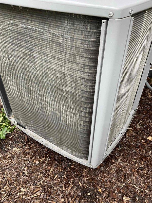 Completed comprehensive BFMA tune-up service on two outdoor air conditioning condensing units at residential property. Performed standard preventive maintenance procedures including inspection of condenser coils, verification of proper airflow through louvered panels, examination of electrical connections and capacitor, and assessment of fan operation. Both units showed good operational condition with protective mesh screens intact and equipment properly maintained on mulched ground surface.