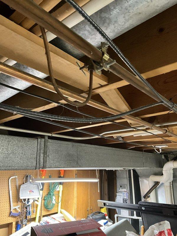 Completed on-site assessment of existing 50-gallon gas water heater and related plumbing components in residential basement. Evaluated current installation including water heater unit, gas shutoff valve, and two basement saddle valves for replacement. Documented existing conditions through photographic documentation showing exposed ceiling joists, copper piping connections, concrete block foundation walls, and current water heater configuration. Provided separate estimates for replacement of gas water heater unit, gas shutoff valve upgrade, installation of leak protection pan, and replacement of both saddle valves to bring system up to current plumbing standards in 50-year-old home.