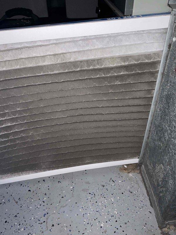 Completed comprehensive BFMA tune-up service on 12-year-old residential air conditioning system. Inspected indoor air handler unit and documented heavily soiled air filter with significant dust accumulation requiring replacement. Evaluated outdoor condensing unit with weathered coil fins showing debris buildup and discoloration; coils displayed typical outdoor exposure with mulch, leaves, and organic matter accumulation around unit perimeter on concrete pad.