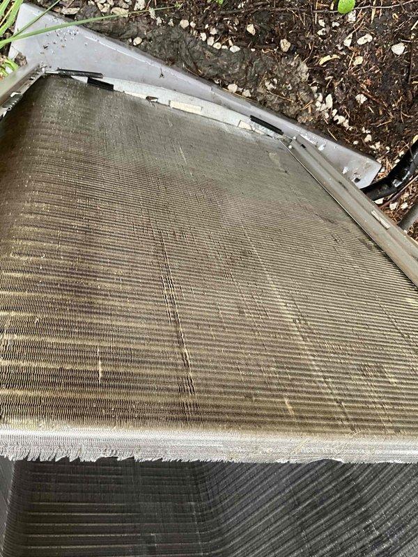 Completed comprehensive BFMA tune-up on residential air conditioning system with equipment over one year old. Replaced heavily soiled air filter showing significant dust and debris accumulation throughout pleated media. Cleaned outdoor condenser unit coils which displayed substantial dirt buildup and reduced airflow efficiency across aluminum fins. System restored to optimal operating condition with improved air quality and heat transfer capability.