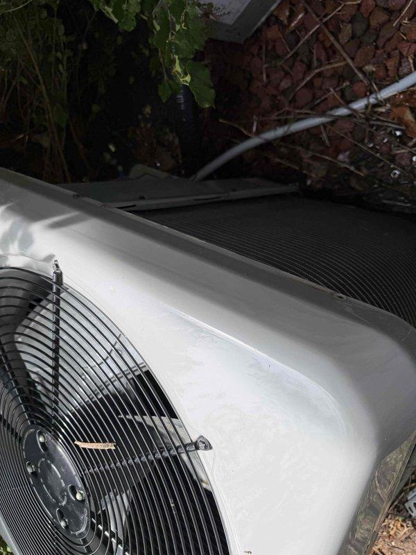 Returned to address previous frozen evaporator coil issue on residential air conditioning system. Upon inspection, discovered outdoor condenser coil heavily contaminated with organic growth, moss, algae, and debris accumulation restricting airflow through fins. Condenser coil showed significant dark discoloration and biological buildup across horizontal fin surfaces. Performed thorough condenser coil cleaning to restore proper airflow and heat transfer capability. Cleared surrounding area of leaves, twigs, and organic debris that had accumulated around unit base. Verified refrigerant lines and connections secure. System operational following coil cleaning with improved airflow through condenser unit.