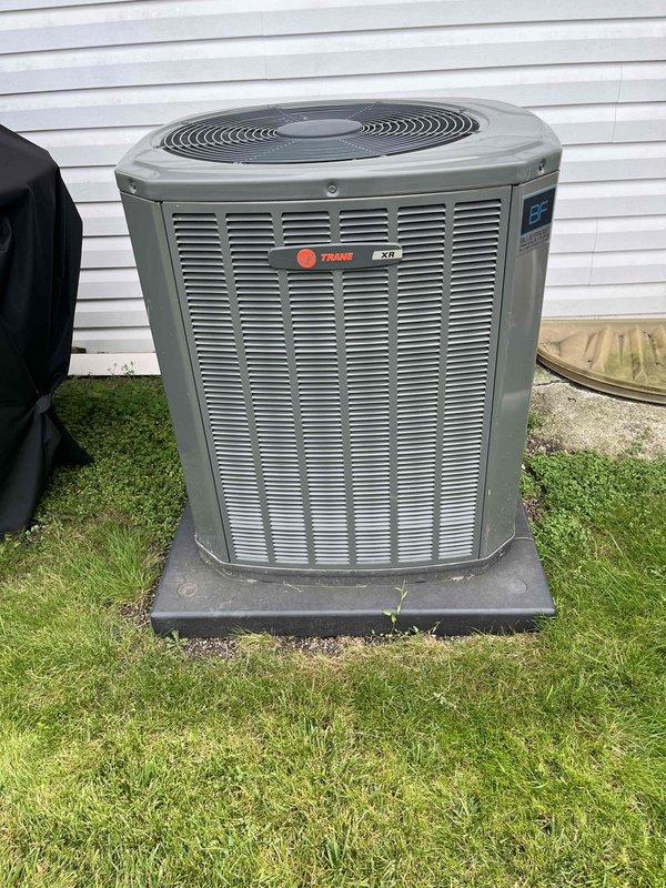 Completed comprehensive BFMA tune-up service on a 5+ year old Trane XR air conditioning system. Upon inspection, discovered significant frost and ice accumulation on the evaporator coil, indicating restricted airflow or possible refrigerant issues. Performed standard maintenance protocol including inspection of outdoor condenser unit, which showed normal operating condition with adequate clearance and proper placement on concrete pad. Assessed copper refrigerant lines showing age-appropriate oxidation and discoloration. Documented system conditions with photographic evidence of both outdoor condenser unit and indoor evaporator coil assembly with ice buildup for further evaluation and potential follow-up service recommendations.