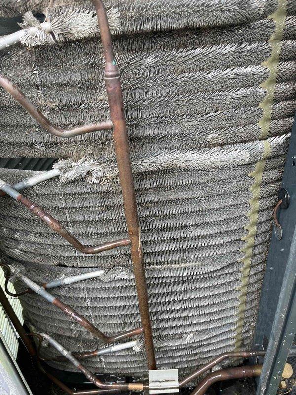 Completed comprehensive BFMA tune-up service on a 5+ year old Trane XR air conditioning system. Upon inspection, discovered significant frost and ice accumulation on the evaporator coil, indicating restricted airflow or possible refrigerant issues. Performed standard maintenance protocol including inspection of outdoor condenser unit, which showed normal operating condition with adequate clearance and proper placement on concrete pad. Assessed copper refrigerant lines showing age-appropriate oxidation and discoloration. Documented system conditions with photographic evidence of both outdoor condenser unit and indoor evaporator coil assembly with ice buildup for further evaluation and potential follow-up service recommendations.