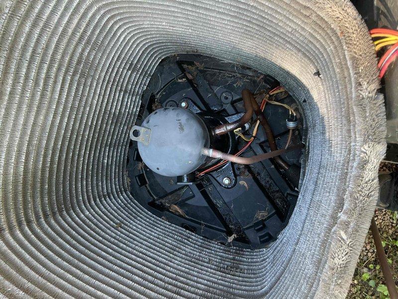 Completed comprehensive BFMA tune-up service on residential air conditioning system over 4 years old. Performed standard maintenance protocol including removal of top grille to access condenser unit, inspected compressor assembly and refrigerant lines, verified fan motor operation and blade condition, and assessed heat exchanger coil fins for proper airflow. Cleaned debris and accumulated dirt from internal components and exterior housing, documented equipment condition with photos showing normal wear consistent with age and outdoor exposure.