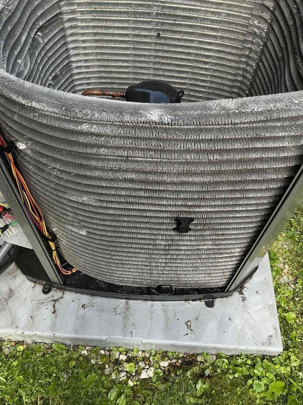 Completed comprehensive BFMA tune-up service on residential air conditioning system with equipment age of 1+ years. Performed standard maintenance protocol including inspection of condenser unit, evaluation of coil conditions, and assessment of refrigerant lines. Both the cylindrical top-discharge condenser coil and rectangular coil assembly showed significant accumulation of dirt, dust, and debris on fin surfaces, which can restrict airflow and reduce system efficiency. Documented equipment condition through photographic records showing outdoor unit mounted on concrete pad with visible weathering and contamination on coil surfaces. All components were evaluated for proper operation and system readiness.