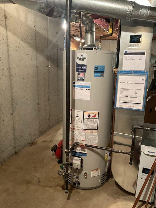 Completed installation of a 50-gallon Bradford White tanked water heater in basement utility area. Unit was properly positioned, connected to existing plumbing lines with appropriate inlet and outlet piping, and integrated with HVAC ductwork. All connections were secured with code-compliant fittings, safety valves installed, and system tested for proper operation and leak-free performance.