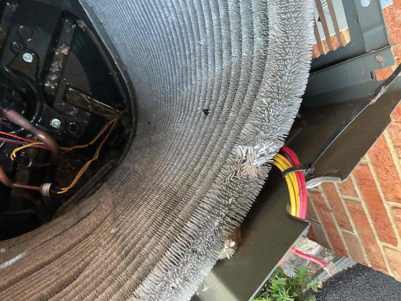 Completed comprehensive BFMA tune-up on 4-year-old HVAC system, including full AC maintenance per contract specifications. Inspected blower assembly and noted dust accumulation on squirrel cage fan blades; observed significant frost buildup on outdoor condenser coil indicating potential refrigerant flow restriction or low charge condition. Documented equipment condition with photos and recommended follow-up service to address icing issue and restore proper system operation.