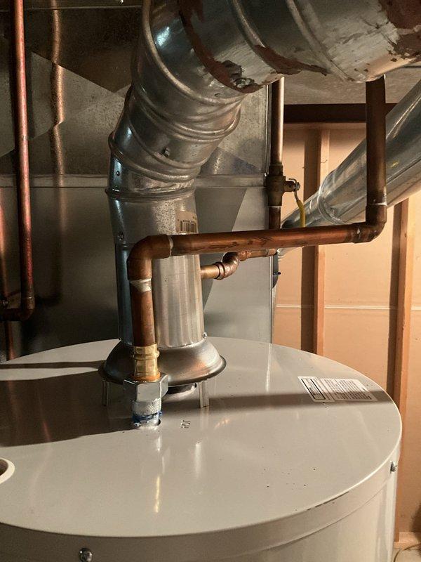 Responded to service call for Bradford White tanked water heater installation issue. Upon inspection, identified that pressure release valves were positioned too close to the air return ductwork, creating insufficient clearance for proper operation and code compliance. Documented existing conditions with photographs showing water heater, copper piping connections, and HVAC ductwork proximity. Will need to return to relocate pressure relief valve or adjust ductwork positioning to achieve adequate clearance and ensure safe operation of safety mechanisms.