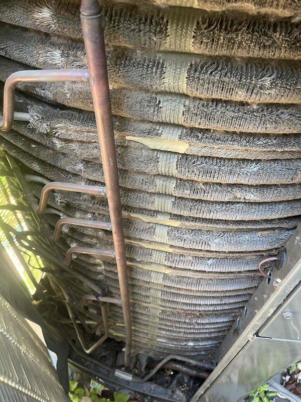 Completed comprehensive BFMA air conditioning tune-up on 4-year-old system. Performed full system inspection including evaporator coil assessment, refrigerant line examination, and operational testing. Documented heavy dust and debris accumulation on cylindrical evaporator coil assembly with visible contamination across finned surfaces, copper refrigerant lines showing normal oxidation patina, and evidence of previous repairs with tape reinforcement on coil sections. Verified all mechanical components, conducted standard maintenance procedures per BFMA protocol, and ensured system operational efficiency. Unit running within normal parameters upon completion.