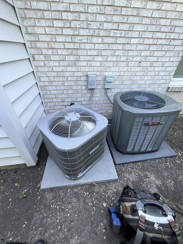 Completed comprehensive air conditioning tune-up on two residential condenser units, including a Trane system and a secondary unit, both positioned on exterior concrete pads. Performed standard preventive maintenance procedures including inspection of electrical connections, refrigerant levels, condenser coil cleaning, fan motor operation verification, and capacitor testing on both units. Inspected and documented the 16x25x1 pleated air filter showing moderate dust accumulation, confirmed proper airflow direction marking, and verified filter housing integrity within the indoor air handler unit.