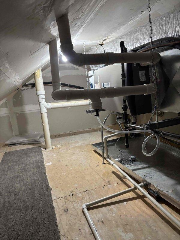 Installed drainage system to fresh air intake in attic mechanical space per customer request. Routed PVC piping across plywood flooring to prevent condensate accumulation at intake point, ensuring proper moisture management for HVAC system operation. All work completed in accordance with warranty specifications and manufacturer guidelines.