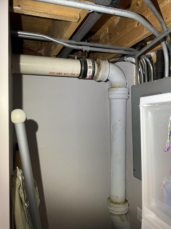 Responded to service call for leaking outside spigot and noisy toilet. Upon inspection, accessed crawlspace plumbing infrastructure to assess drainage and supply line conditions. Documented existing PVC-DWV drainage system configuration, noting proper pipe installation and fittings beneath structure. Identified corrosion present on pipe connections requiring attention. Examined coupling connections with rubber fittings and metal clamps, observing deterioration at junction points. Inspected multiple plumbing lines including copper supply lines and insulated pipes in utility space. Captured photographic documentation of plumbing assembly and corrosion areas for service records. Addressed toilet noise issue and exterior spigot leak as reported.