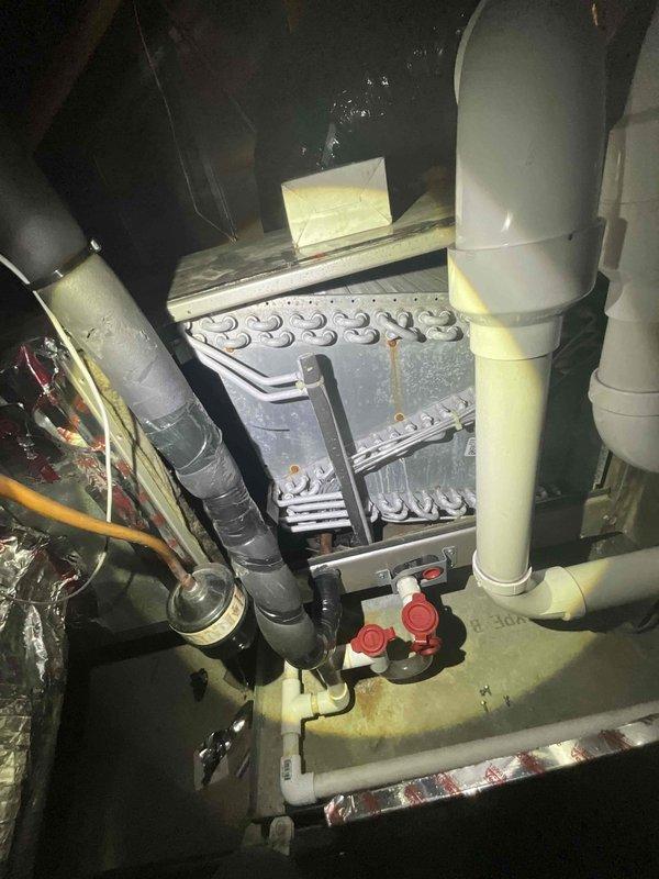 Responded to a no-cooling callback following previous service visit in early July. Upon arrival, found indoor temperature at 78°F with system not operating properly. Performed diagnostic inspection of air handling unit and evaporator coil assembly. Inspected condensate drainage system including drain pan and PVC discharge lines. Examined refrigerant line connections and verified proper installation of all HVAC components. Documented equipment condition with photos showing evaporator coil fins, metal housing panels with dust accumulation, and complete condensate management system with safety switches and drain lines.
