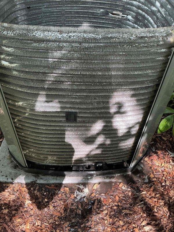 Completed comprehensive BFMA tune-up service on 9+ year old outdoor air conditioning condenser unit during afternoon appointment window. Performed standard AC maintenance protocol including inspection of cylindrical condenser unit with horizontal fin assembly, evaluation of coil condition which showed moderate accumulation of dirt, debris, and environmental particulates between fins, and assessment of unit mounted on concrete pad with mulch landscaping. All components inspected and serviced per manufacturer specifications to ensure optimal system performance for the cooling season.