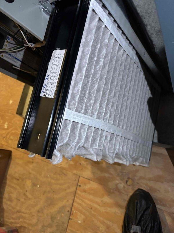 Completed comprehensive BFMA tune-up service on a 9-month-old air conditioning system. Inspected air handler unit and confirmed clean pleated air filter properly seated in housing with secure frame installation. Performed exterior condenser unit evaluation, noting heavy accumulation of dirt, dust, and debris on condenser coil fins requiring cleaning to restore optimal heat transfer efficiency and system performance.