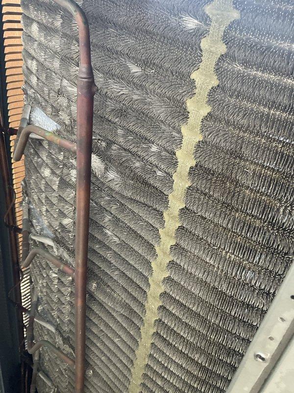 Completed comprehensive air conditioning tune-up on residential system aged 4+ years. Performed standard maintenance procedures including inspection of evaporator coils, which revealed moderate accumulation of dust, pollen, and debris between fin sections with notable discoloration present on center coil surfaces. Verified refrigerant lines and copper connections for proper operation. Inspected air handler unit and confirmed pleated air filter installation and secure mounting. System operational and ready for continued service.