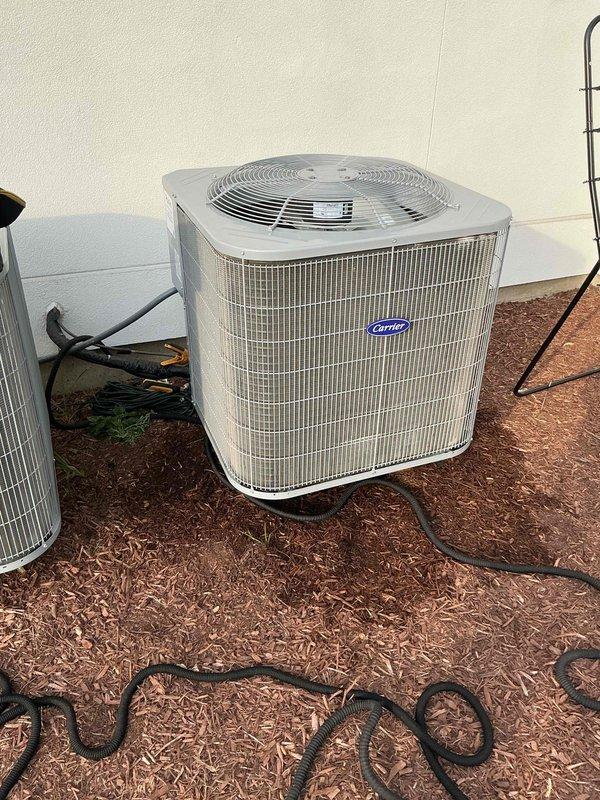 Completed comprehensive air conditioning tune-up service on two Carrier condenser units. Performed standard maintenance procedures including inspection of electrical components, refrigerant lines, and condenser coils. One unit was found with significant damage to the top protective grille and casing, exposing internal condenser coil and compressor components, with torn insulation material present; documented condition with photographs for customer review and future repair consideration.