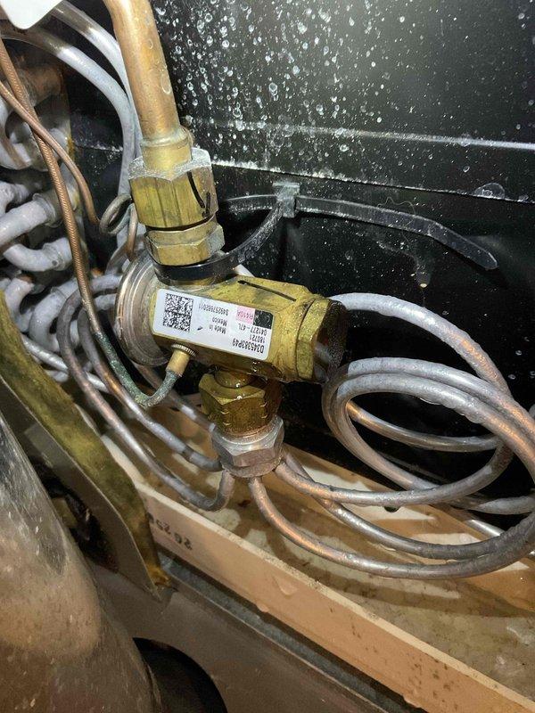 # HVAC Service Completed

Responded to residential no cooling call with thermostat set to 68°F but temperature holding at 75°F. Inspected Goodman packaged unit model PPGD048036AA, manufactured August 2018, utilizing R410A refrigerant. Upon inspection, observed significant condensation on interior metal panel indicating active cooling cycle but insufficient heat transfer. Examined refrigerant distribution valve assembly and associated copper line connections for potential restrictions or refrigerant flow issues. Documented equipment nameplate specifications and internal valve configuration with service photos. Unit assessed for proper refrigerant charge levels, airflow restrictions, and component operation to determine root cause of inadequate cooling performance.