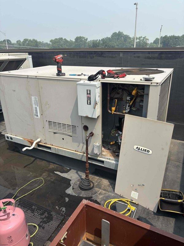 Responded to commercial AC service call for unit not cooling below 80°F despite thermostat set to 60°F. Accessed rooftop unit and discovered severely corroded blower motor assembly and deteriorated interior cabinet components with extensive rust damage throughout. Added refrigerant to system and performed necessary repairs to restore cooling operation, though unit shows significant age-related deterioration requiring monitoring for future replacement consideration.