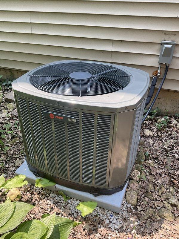 Performed comprehensive BFMA tune-up on Trane air conditioning system including complete inspection of condenser unit, verification of electrical connections and capacitor function, and assessment of refrigerant lines. Observed mineral deposits and white residue accumulation on condenser coil surfaces requiring attention during service, cleaned accessible components, and verified proper system operation. Unit is operational with all safety checks completed and system running within normal parameters.