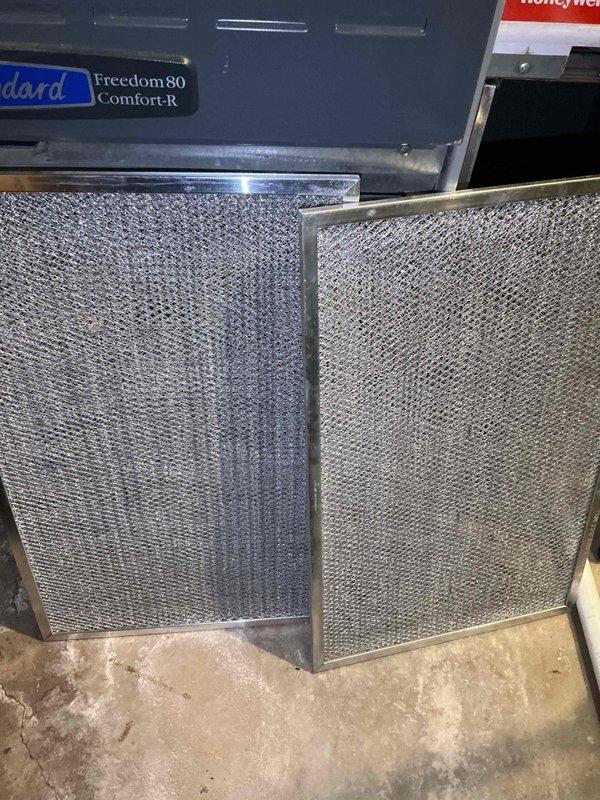 # HVAC Maintenance - BFMA Tune Up

Completed comprehensive preventive maintenance tune-up on a 17-year-old Freedom80 Comfort-R HVAC system. Performed standard inspection and cleaning procedures on both indoor and outdoor components. 

Inspected and compared return air filters, noting significant dust and debris accumulation on existing filter requiring replacement. Filter showed heavy brownish-gray coating across mesh surface, restricting proper airflow. Installed clean replacement filter to restore optimal system performance and indoor air quality.

Serviced outdoor condenser unit, which exhibited heavy contamination on coil fins. Coil surface displayed thick beige-colored accumulation of dirt, lint, and organic debris creating diagonal stripe pattern across upper portion. Identified dark patches of mold and mildew growth on multiple areas of aluminum fins. Thoroughly cleaned condenser coils to remove environmental buildup and restore heat transfer efficiency. Cleared obstructions fro